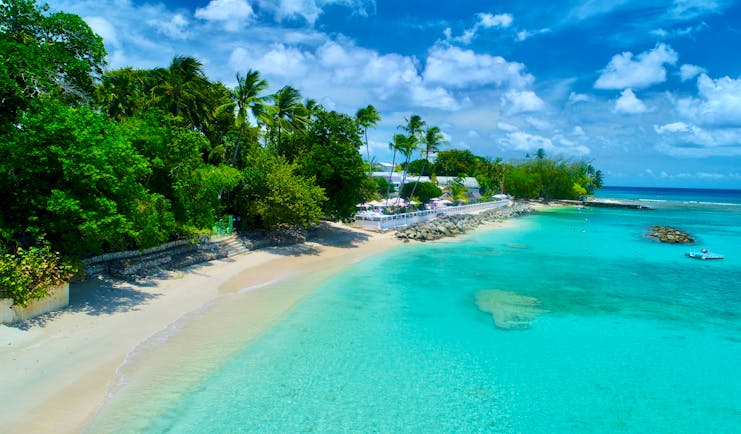 Aerial view of the beach with clear blue sea, sand and greenery