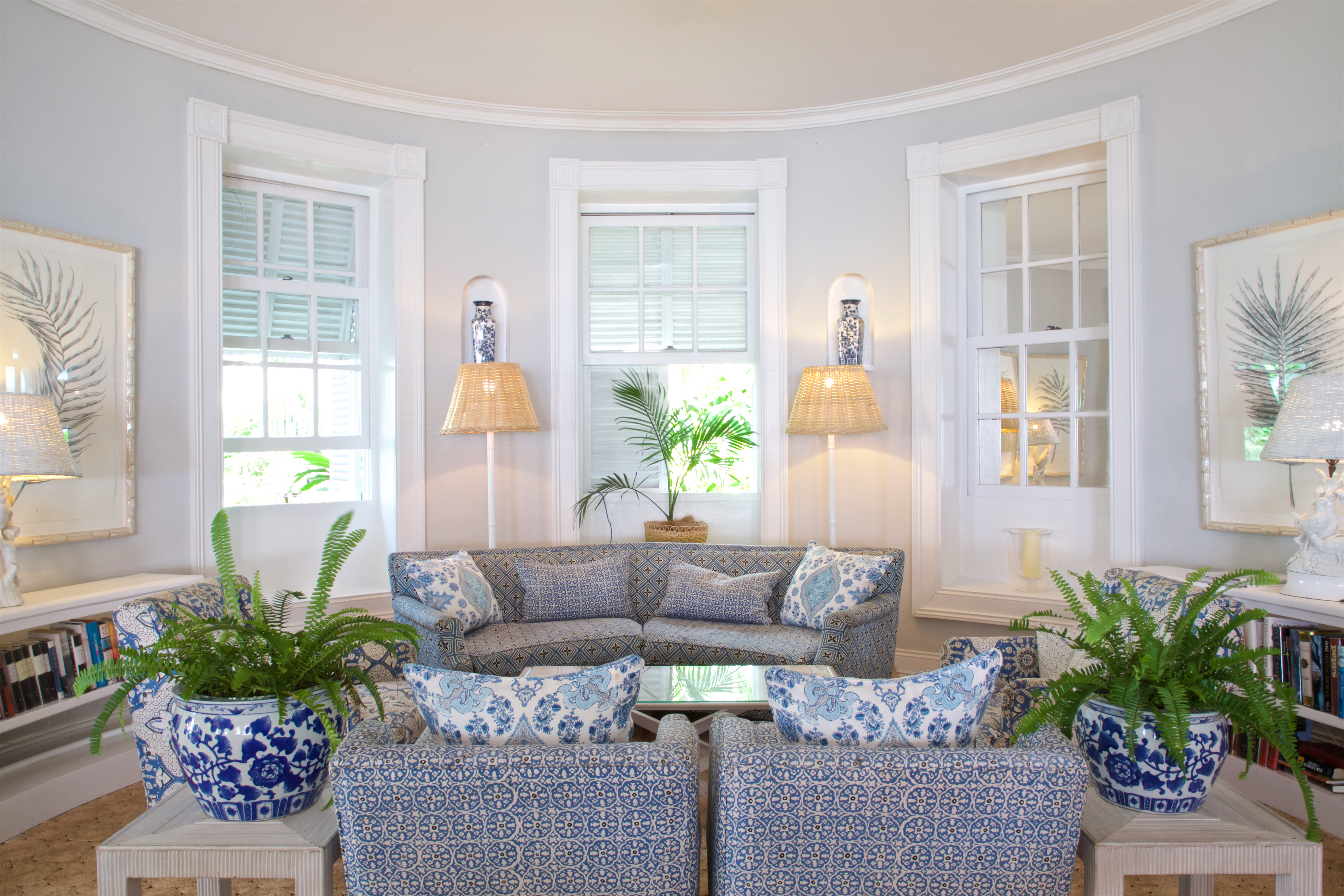 Drawing room with plants in vases, sofas and seating areas in  room with windows