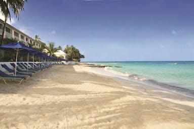 Fairmont Royal Pavilion Barbados beach with sun loungers and umbrellas