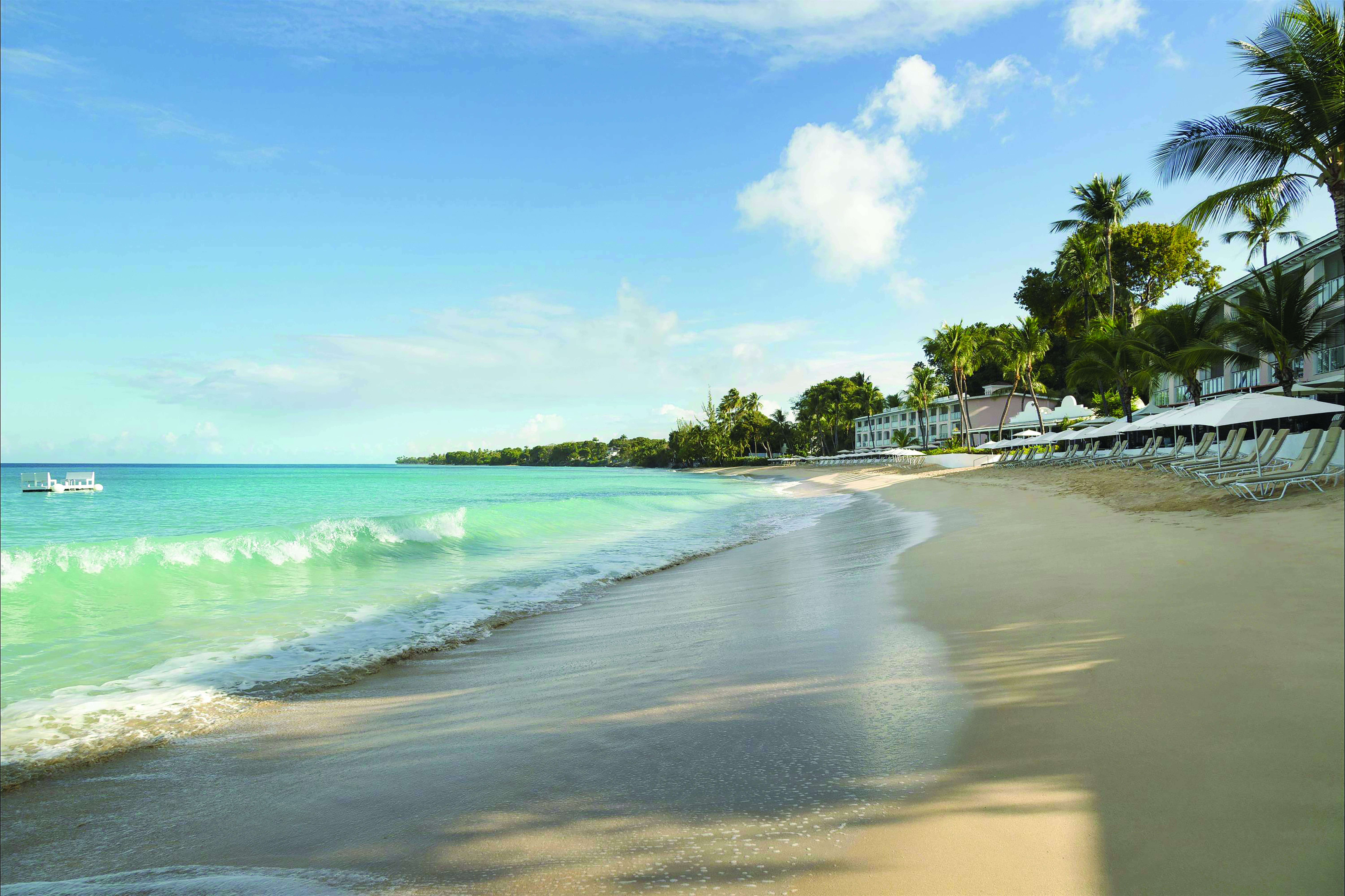Fairmont Royal Pavilion Barbados pool waves lapping the shore sun loungers and umbrellas