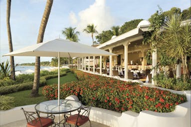 Fairmont Royal Pavilion Barbados outdoor seating beach and restaurant in background