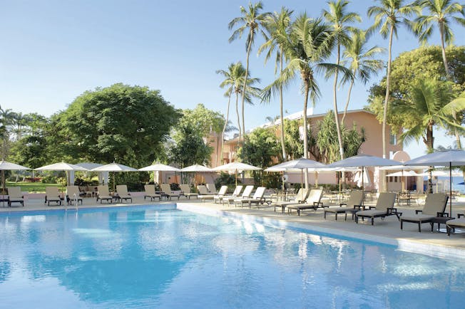 Fairmont Royal Pavilion Barbados pool sun loungers umbrellas and palm trees
