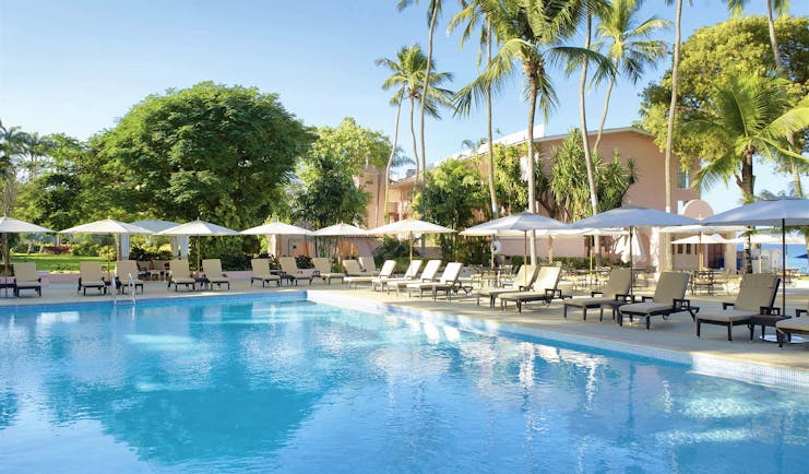 Fairmont Royal Pavilion Barbados pool sun loungers umbrellas and palm trees