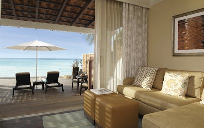 Fairmont Royal Pavilion Barbados suite lounge with private terrace and sun loungers facing the ocean