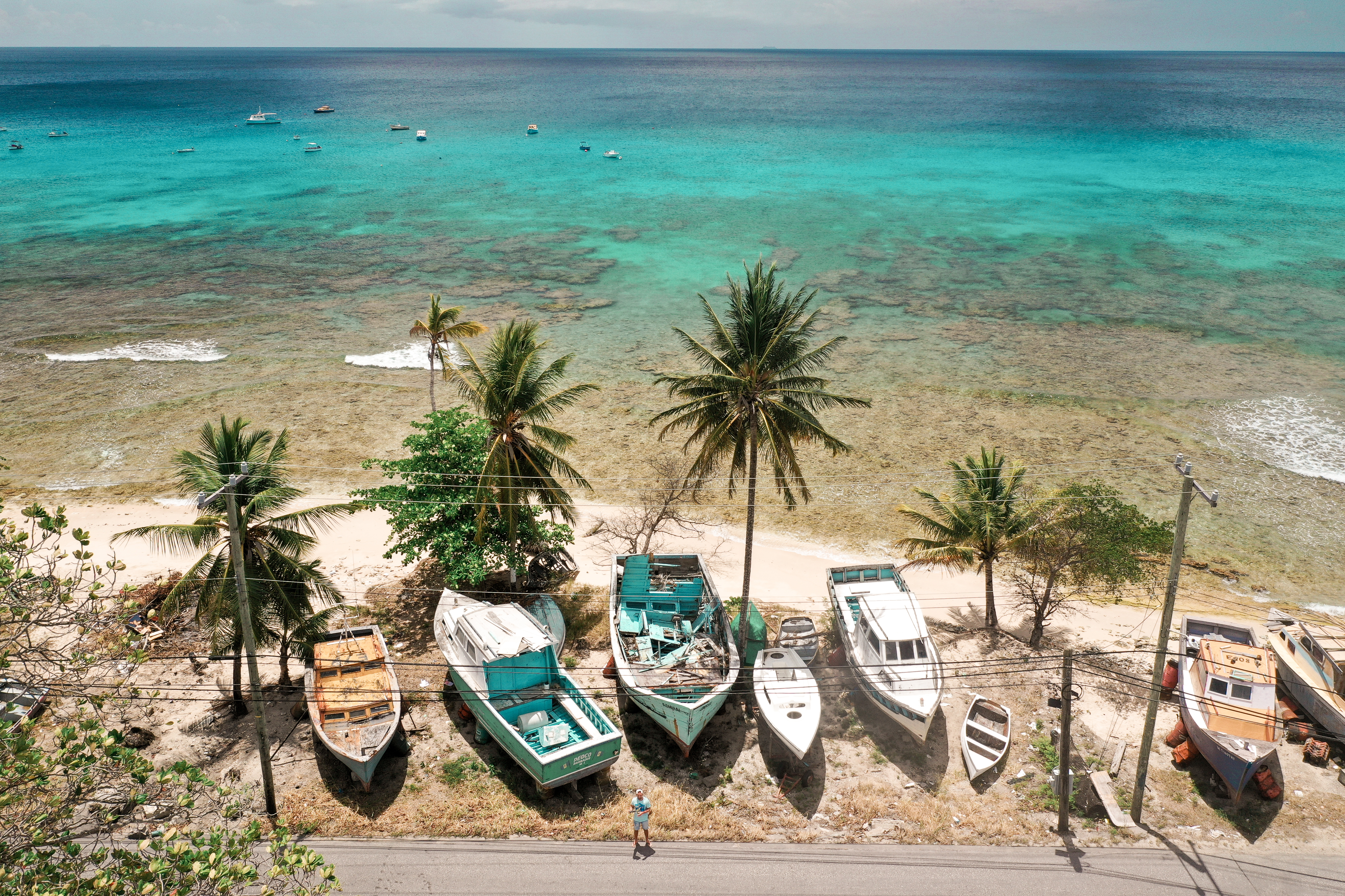 Little Good Harbour a cluster of fishing boats on the sand beside the sea, seen from above