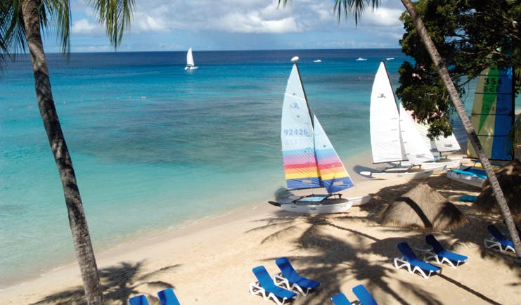 Tamarind Barbados beach white sand clear blue ocean sun loungers boats palm trees