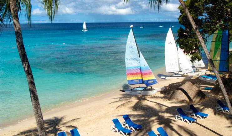 Tamarind Barbados beach white sand clear blue ocean sun loungers boats palm trees