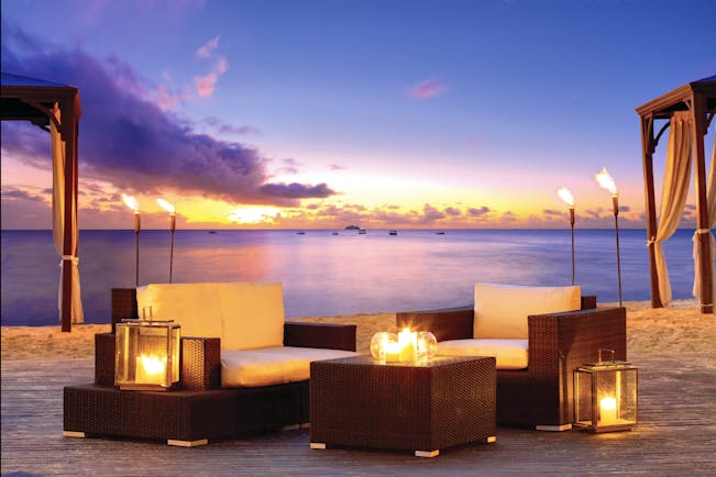 The House Barbados outdoor seating area on the beach at sunset