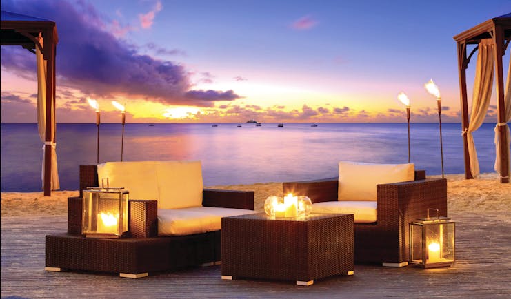 The House Barbados outdoor seating area on the beach at sunset