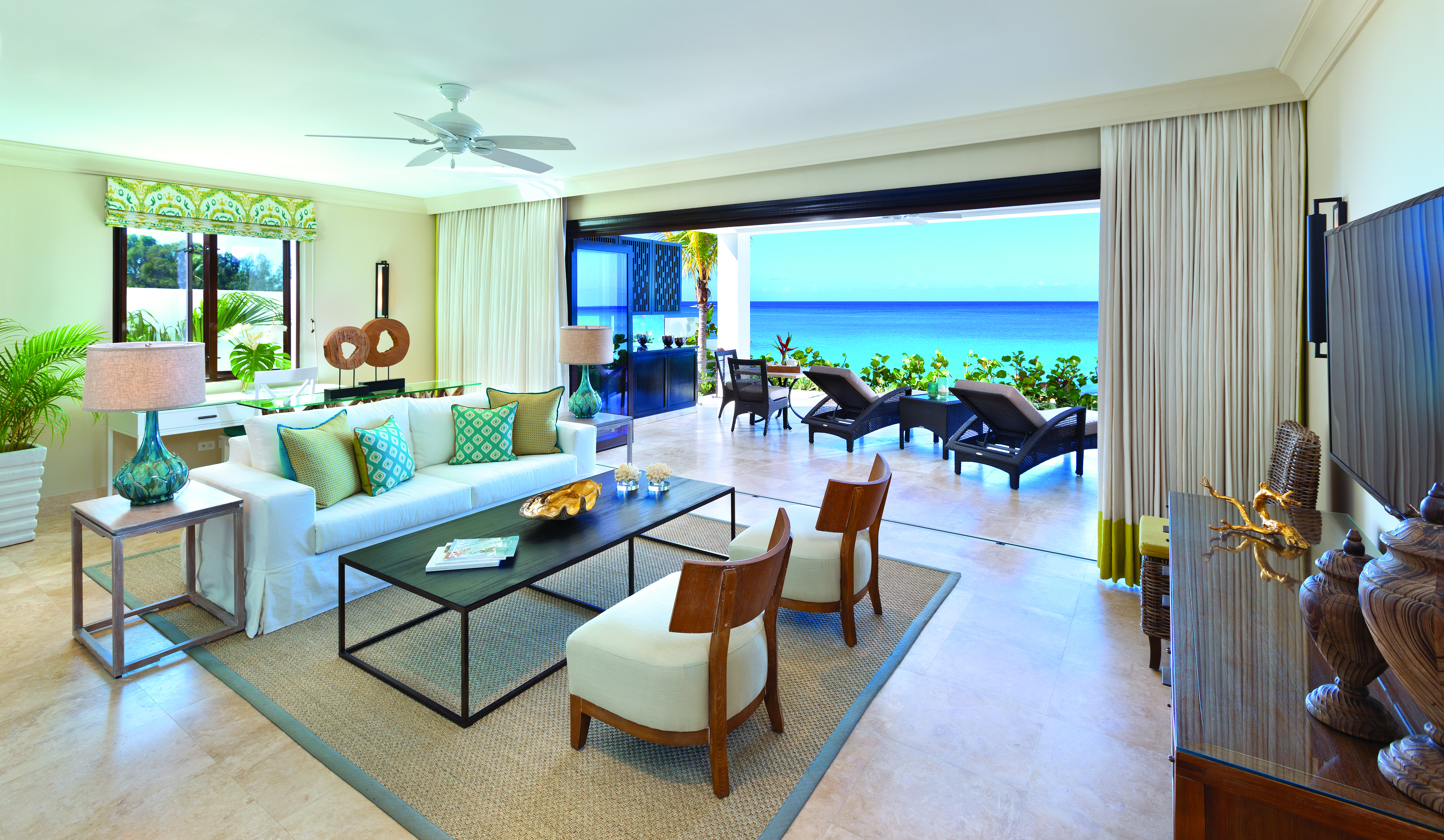 Sandpiper Barbados beach lounge indoor seating area leading to terrace with sun loungers overlooking the ocean