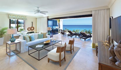 Sandpiper Barbados beach lounge indoor seating area leading to terrace with sun loungers overlooking the ocean