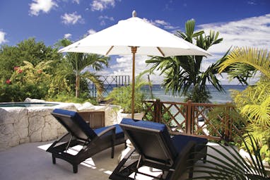 Sandpiper Barbados lounge chairs and umbrella overlooking the ocean