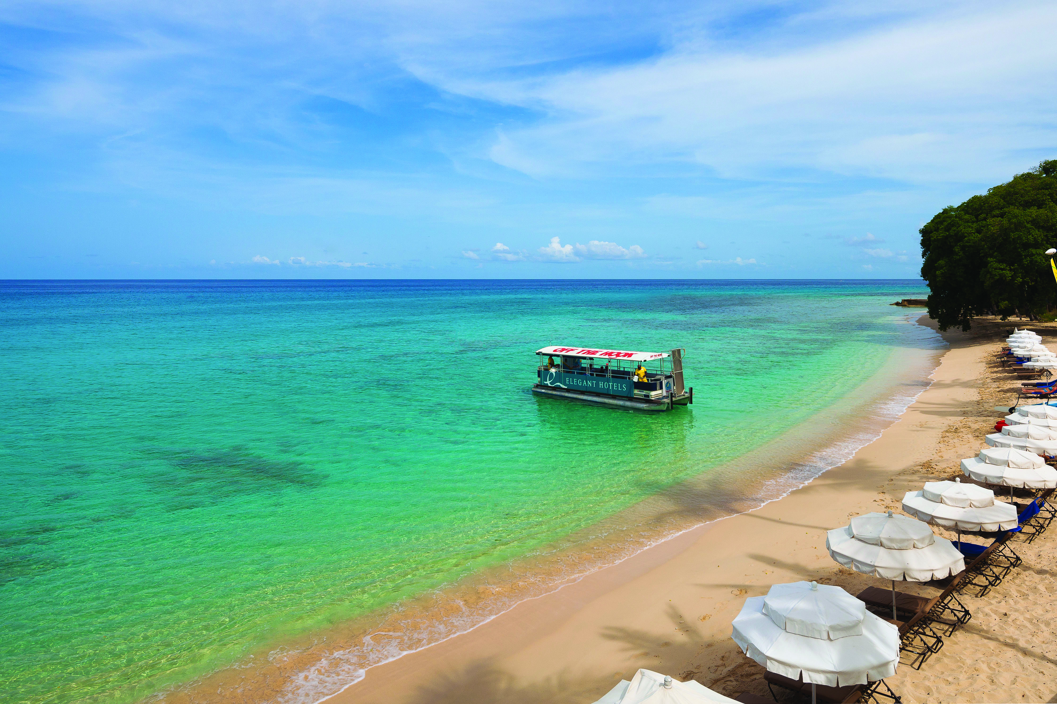 Treasure Beach Barbados beach and umbrellas boat on the water