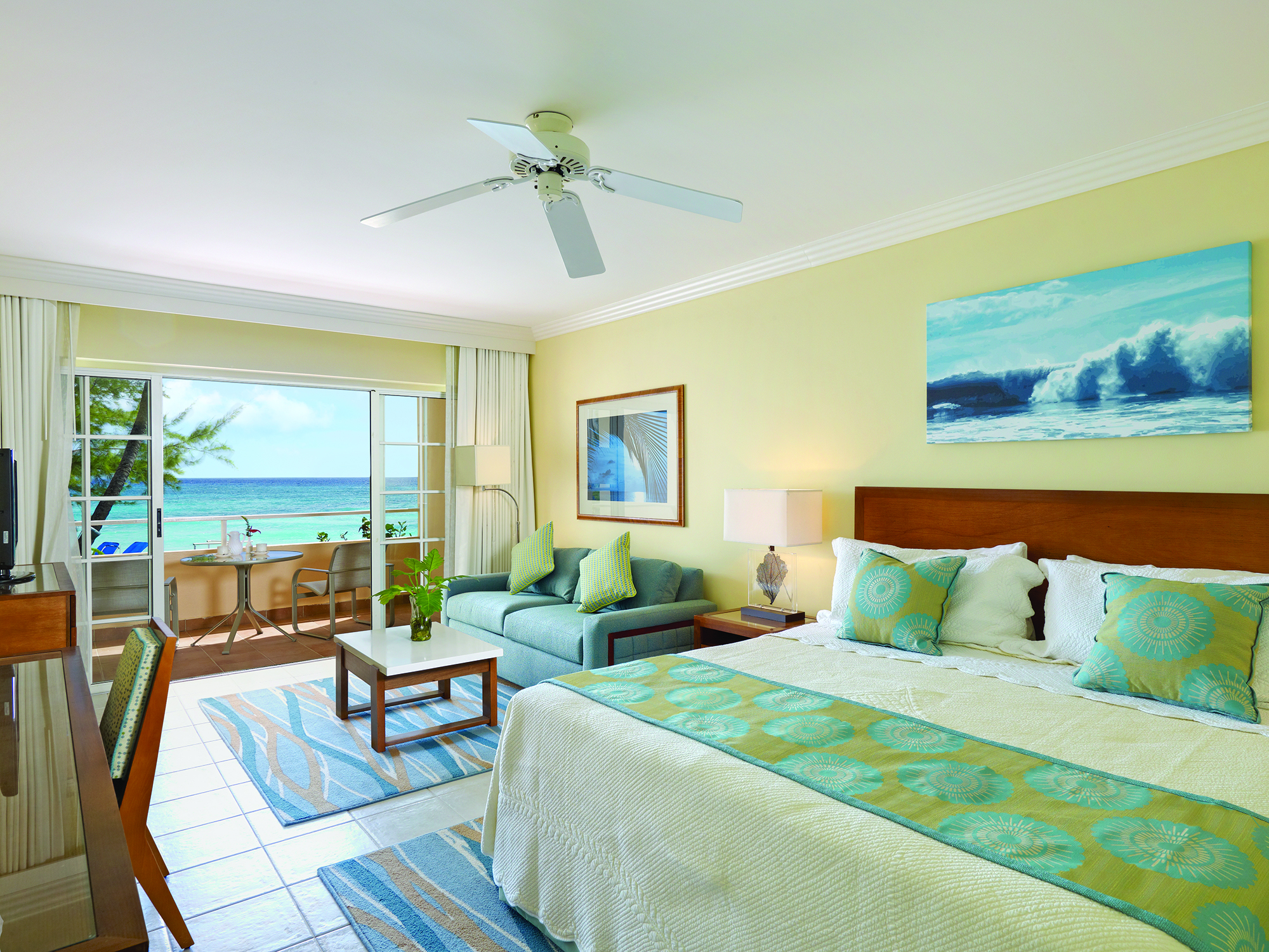 Turtle Beach Barbados ocean view junior suite bedroom with lounge area opening up to balcony overlooking the ocean