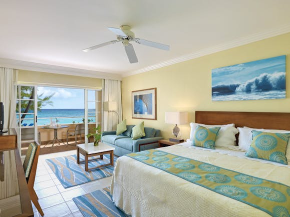 Turtle Beach Barbados ocean view junior suite bedroom with lounge area opening up to balcony overlooking the ocean
