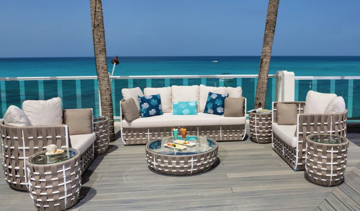 Waves Barbados beach deck outdoor seating area with sofas and chairs on deck overlooking the ocean 