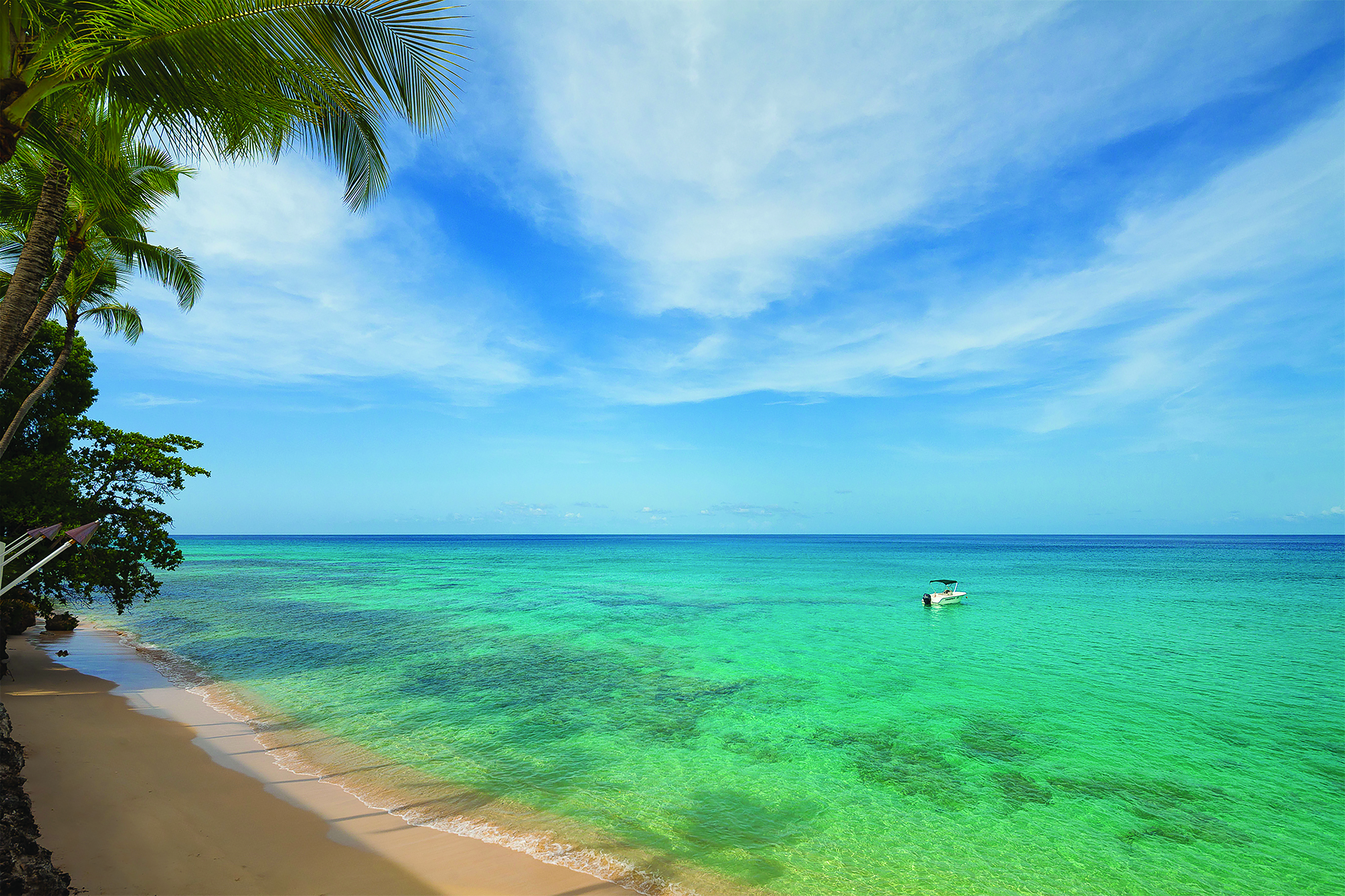 Waves Barbados beach sandy beach and clear blue ocean boat on water