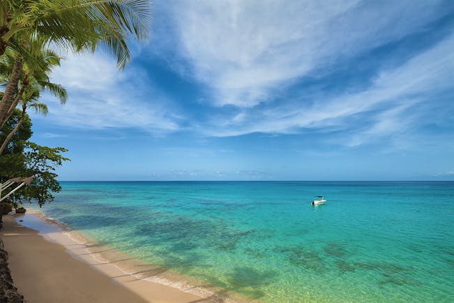 Waves Barbados beach sandy beach and clear blue ocean boat on water