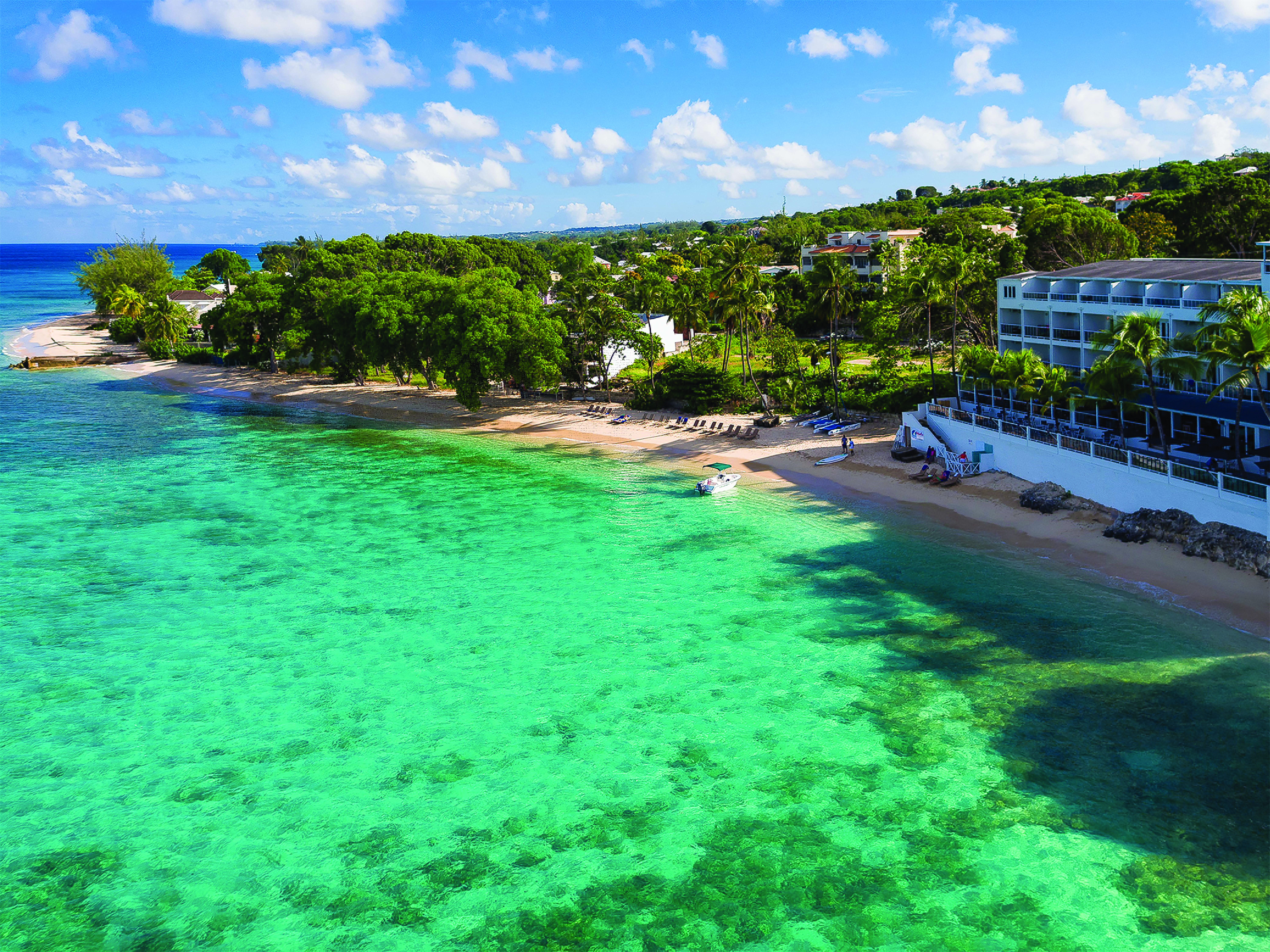 Waves Barbados resort exterior hotel building on sea front ocean and beach in foreground