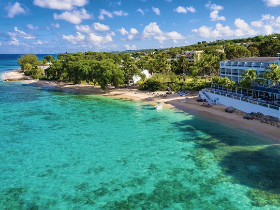 Waves Barbados resort exterior hotel building on sea front ocean and beach in foreground