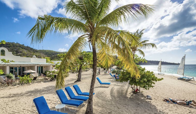 Spice Island Grenada loungers on the beach in the shade of palm trees