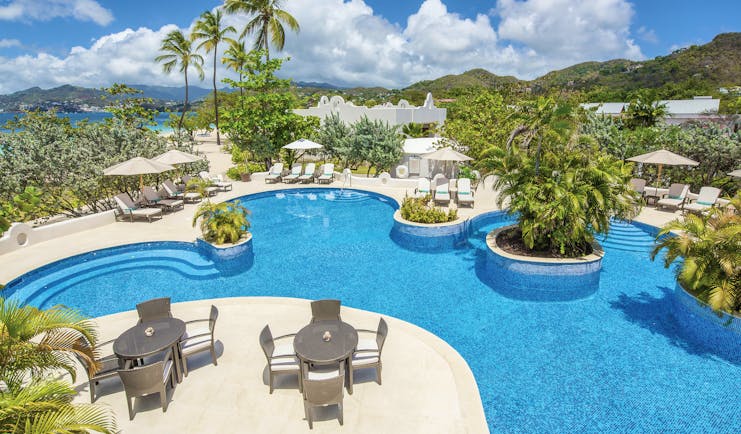 Spice Island Grenada pool with sun loungers and outdoor seating areas