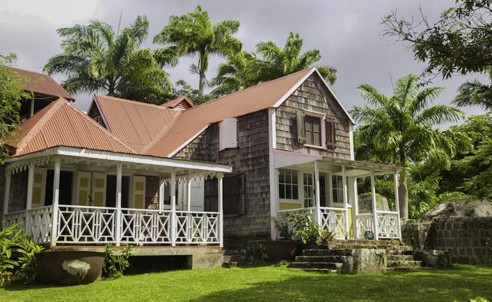 Large Caribbean house with red roof and white verandah at Hermitage Inn Nevis