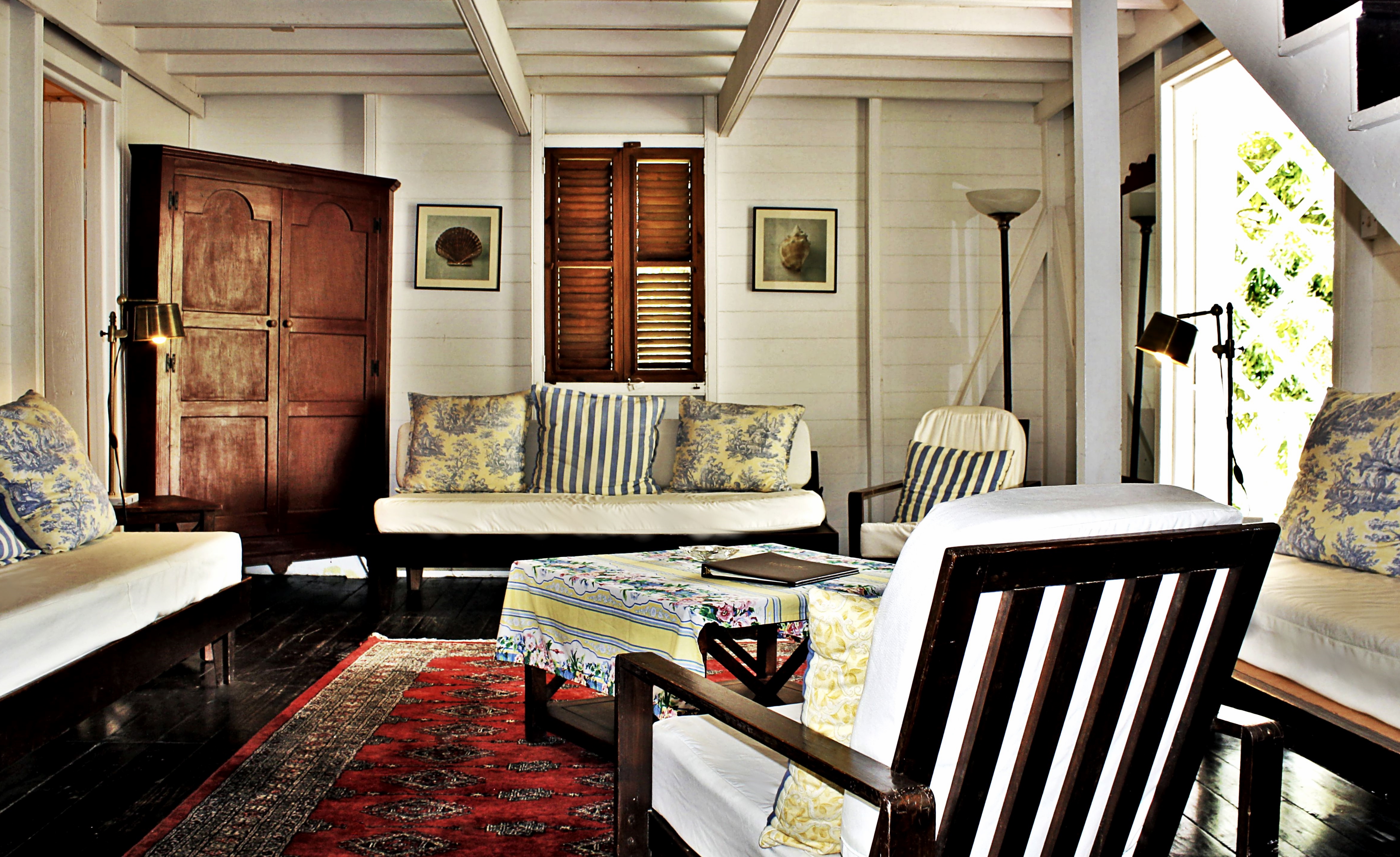White wooden beamed ceiling and walls of lounge with traditional furniture at Hermitage Inn Nevis