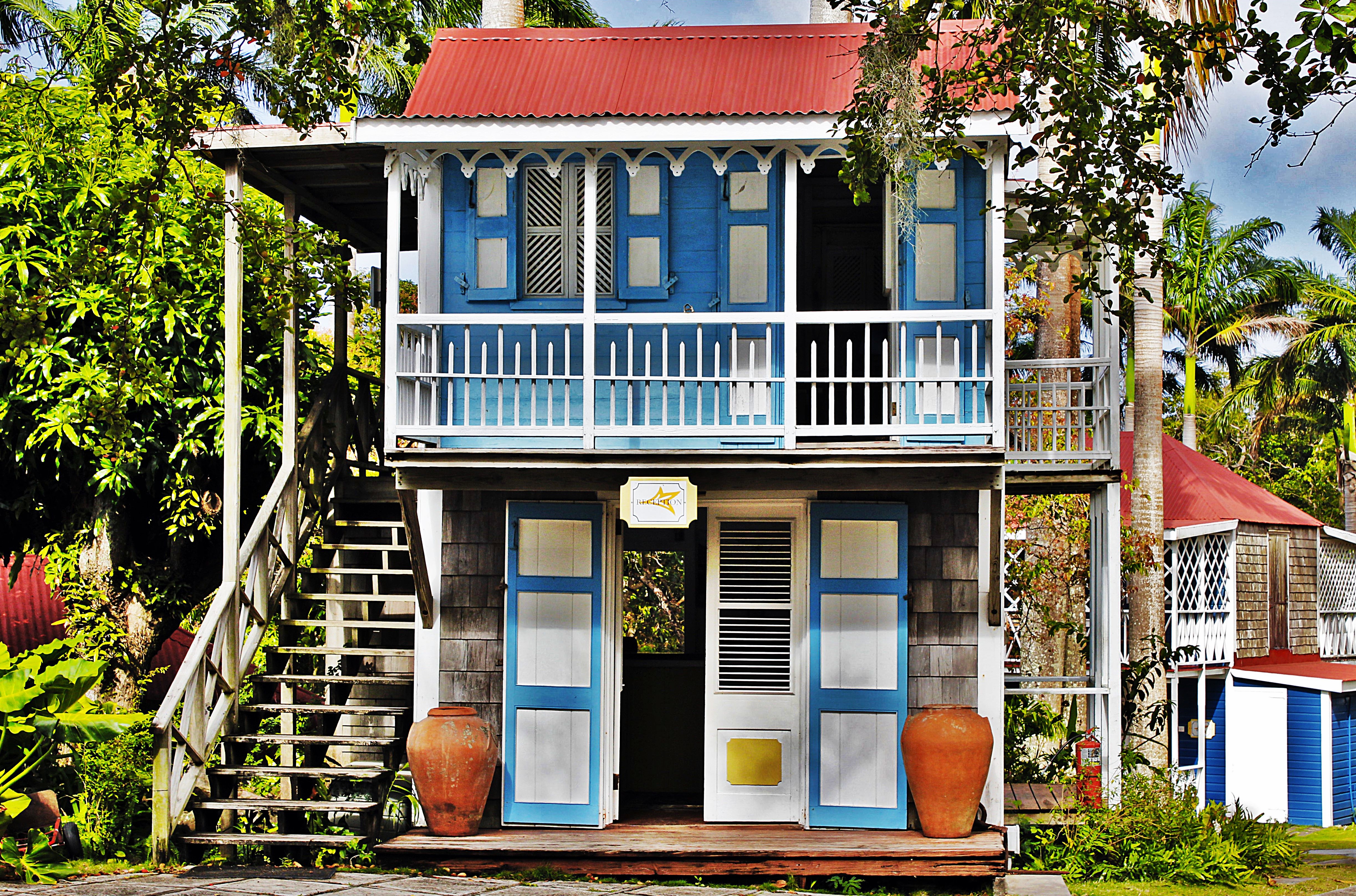 Two storey reception building with red roof and blue and white shutters at Hermitage Inn Nevis