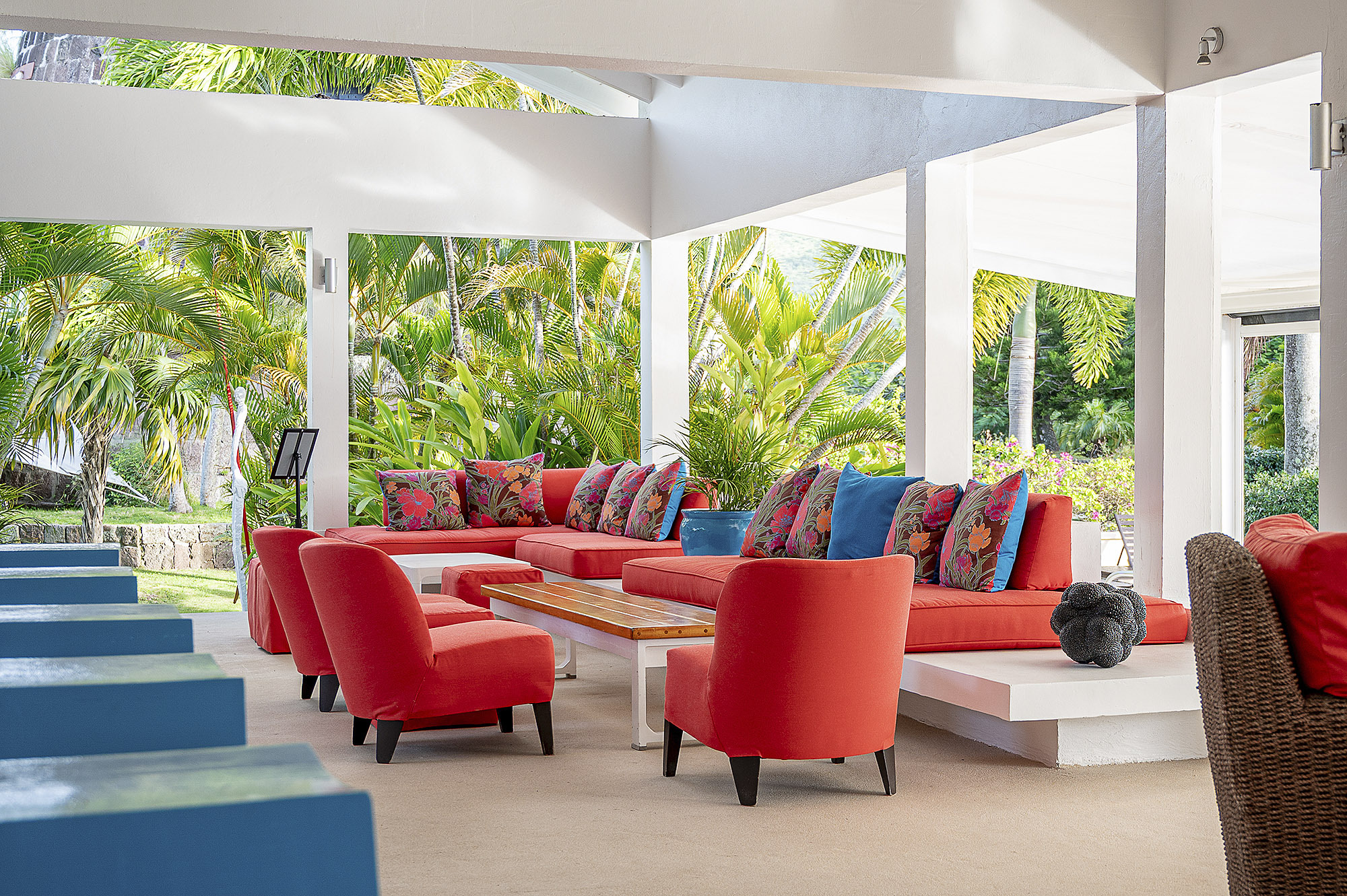Montpelier Nevis bar seating area under white canopy with bright pink-orange and blue sofas and chairs