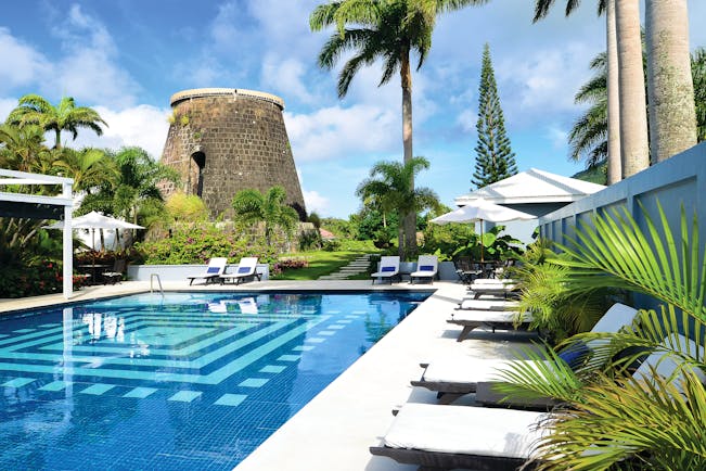 Montpelier Plantation Nevis pool sun loungers historic sugar plantation in the background