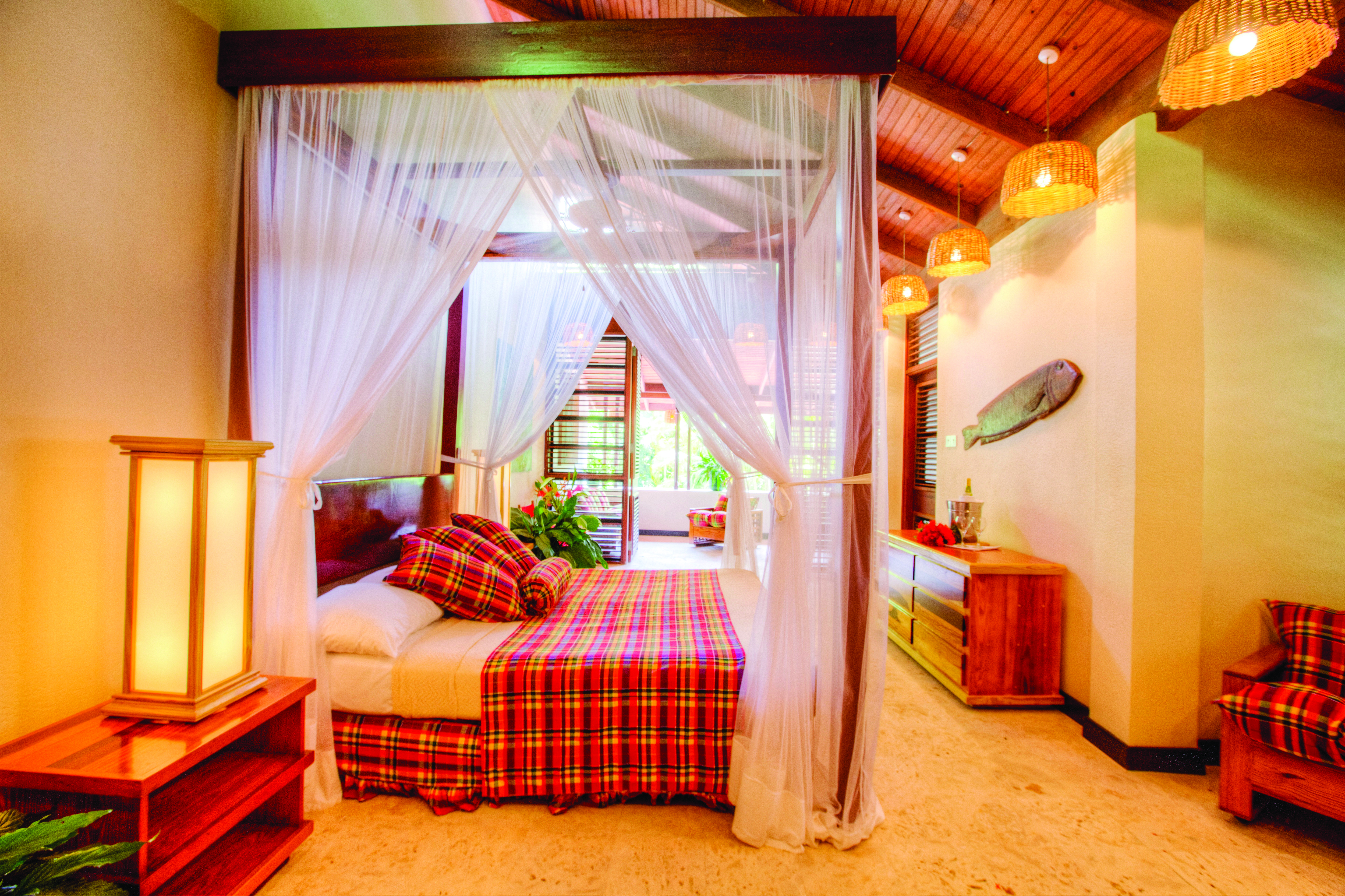 Anse Chastanet St Lucia deluxe beach suite canopied four poster bed lounge area