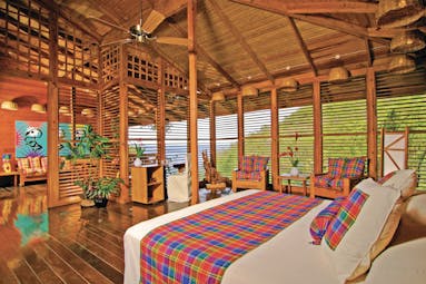 Anse Chastanet St Lucia deluxe hill suite king size bed wooden louvre walls hillside and ocean views