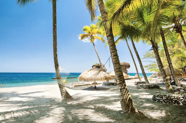 Jade Mountain St Lucia hammock tied between two palm trees on the beach