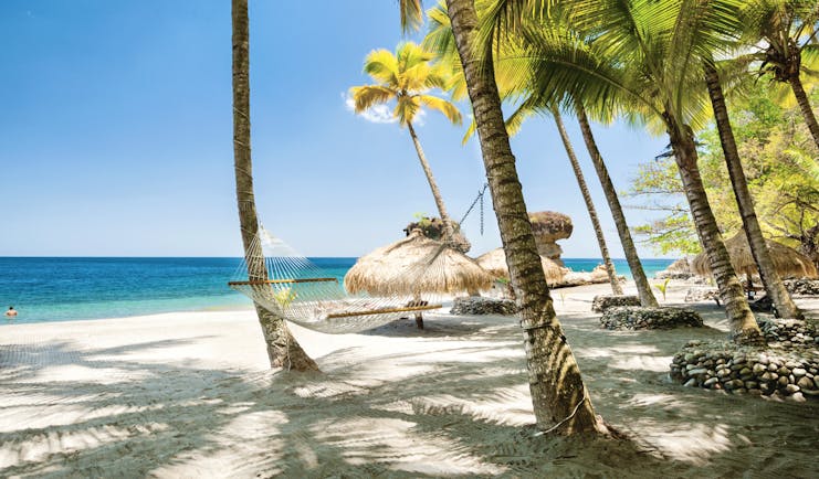 Jade Mountain St Lucia hammock tied between two palm trees on the beach