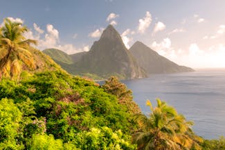 Twin Pitons rock formation in St Lucia, sunset over rocks and ocean