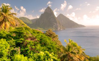 Twin Pitons rock formation in St Lucia, sunset over rocks and ocean