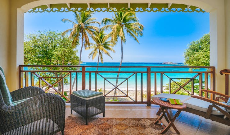 Bequia Beach Hotel balcony, armchair, sun lounger, overlooking beach with white sands and bright blue sea