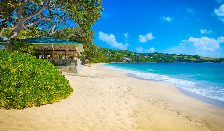 Bequia Beach Hotel Beach, golden sands, bright blue sea, trees and greenery