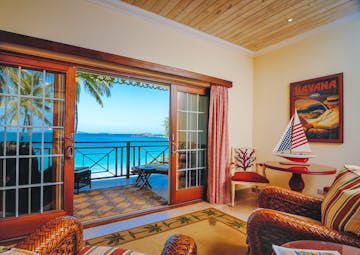 Bequia Beach guestroom balcony, armchairs, bright decor, balcony overlooking beach, white sand, bright blue sea