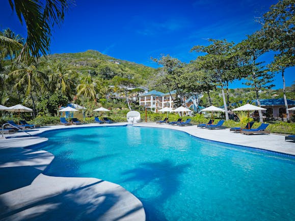 Bequia Beach Hotel pool, sun loungers, umbrellas, greenery