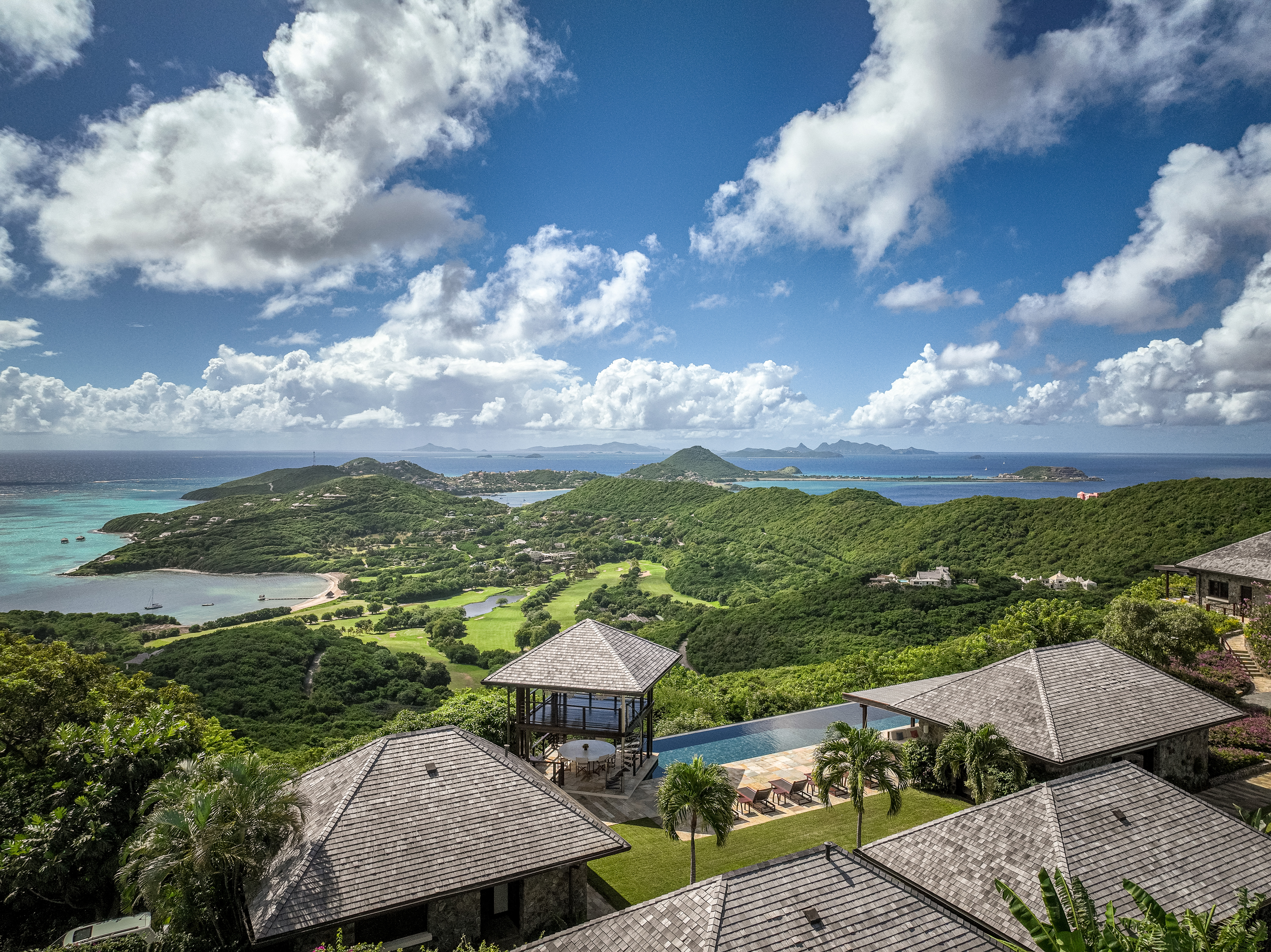 Canouan Estate view from above, showing separate hotel villas leading down green lawns towards the sea