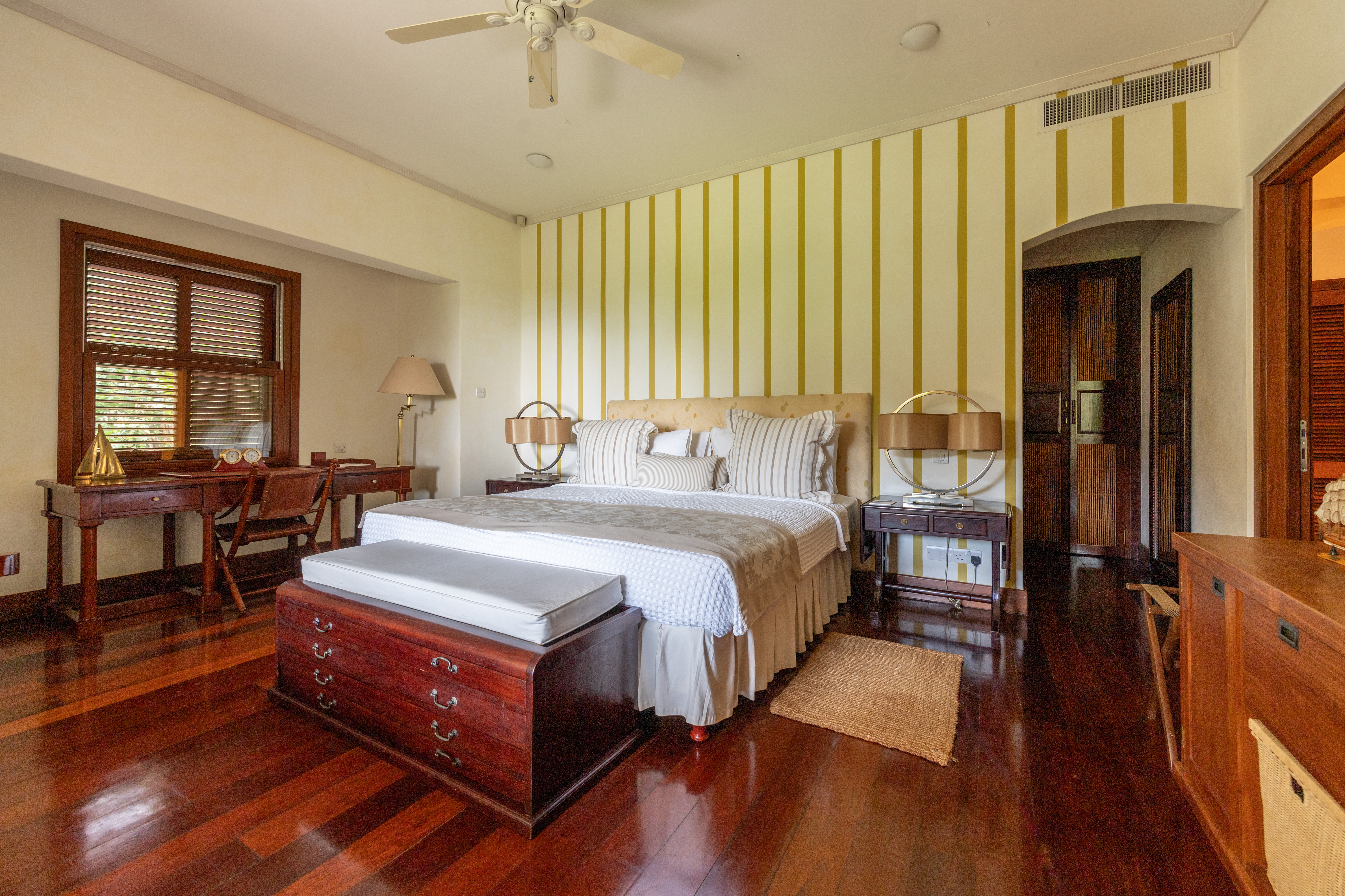 Canouan Estate bedroom with wooden floors, light neutral colour palette, and caribbean charm