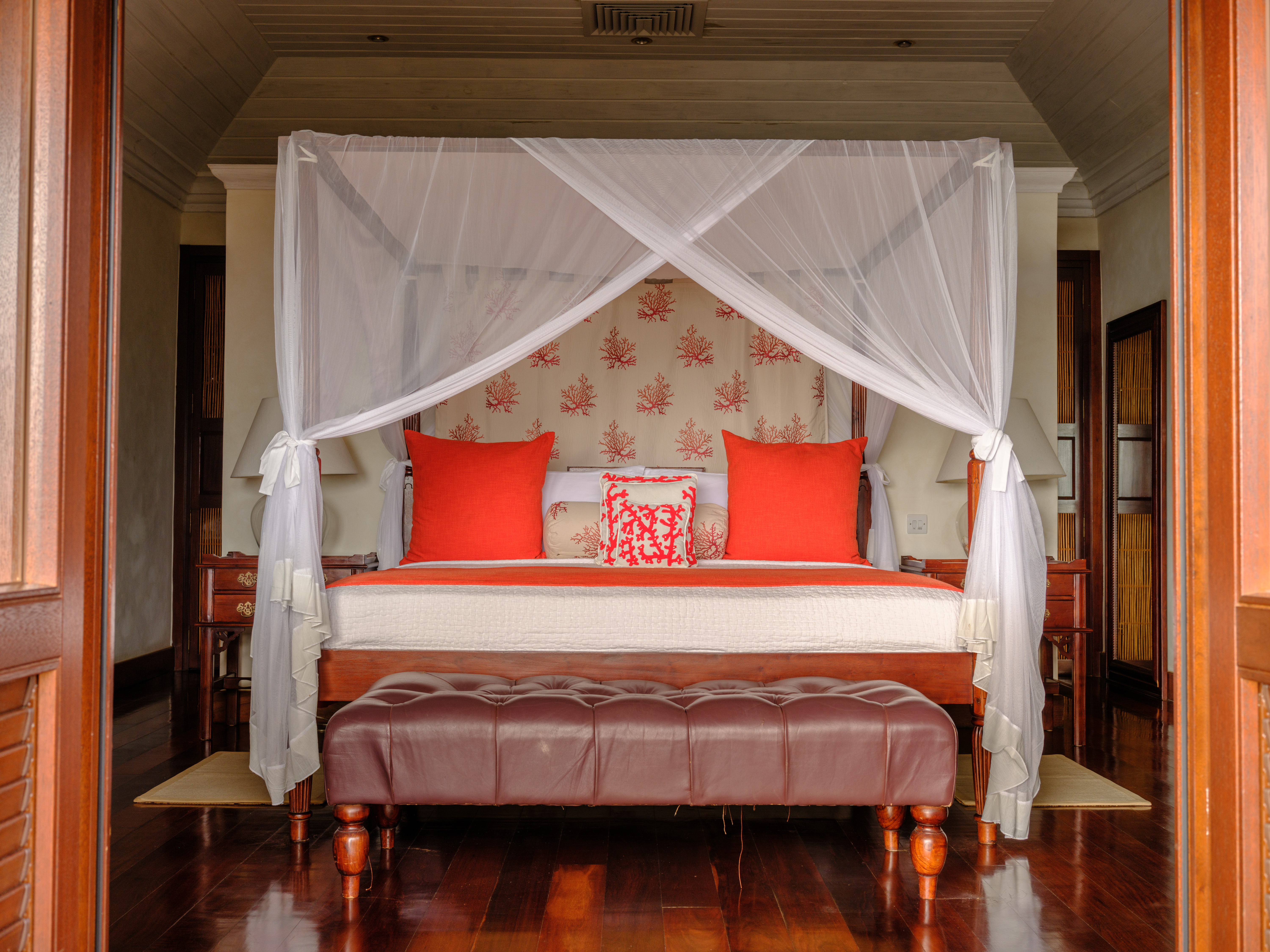 Canouan Estate bedroom, looking straight at the four-poster bed from the outside terrace