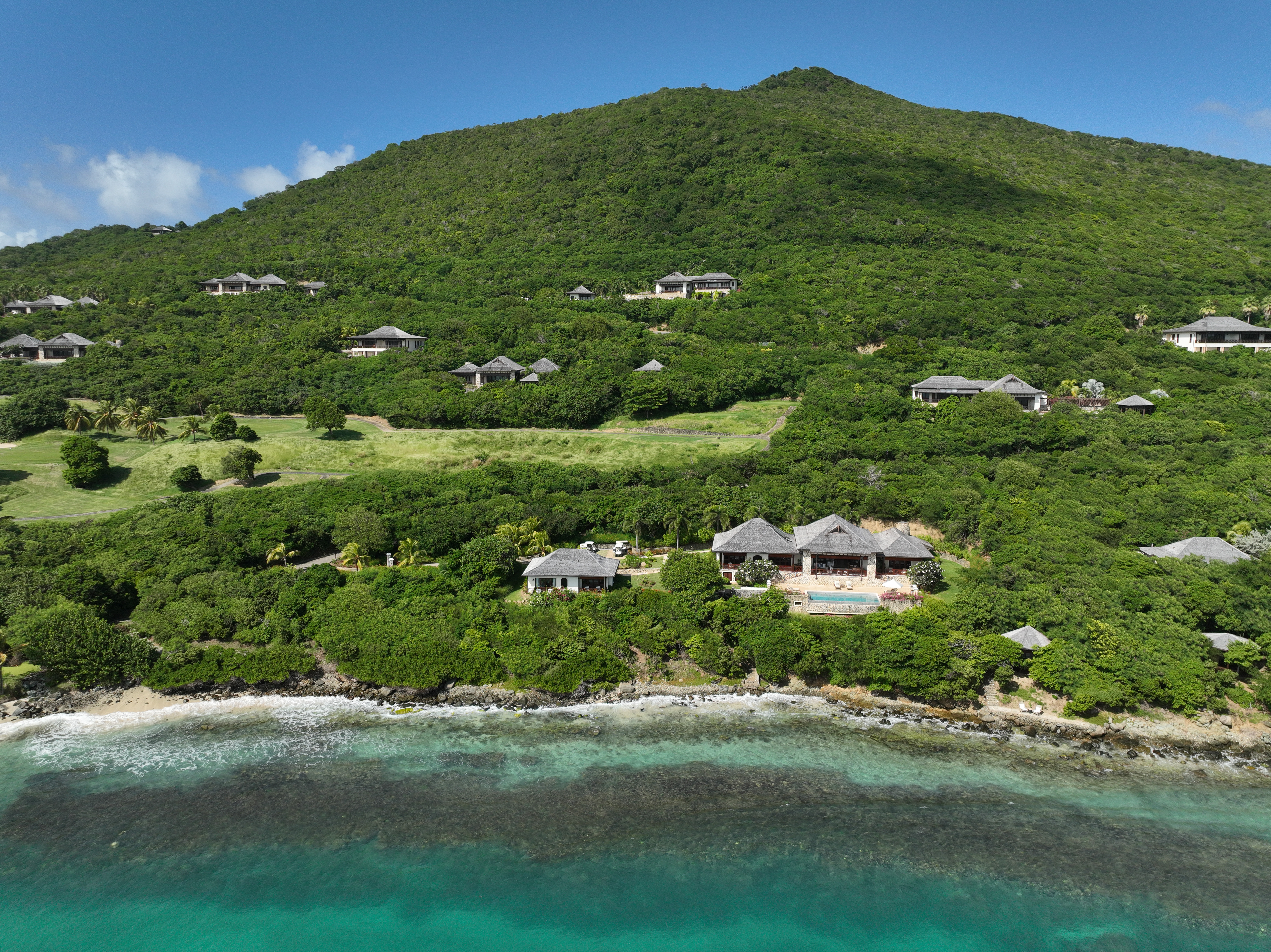Canouan Estate view from the sea looking towards the land, showing the hotel villas emerging from the vegetation