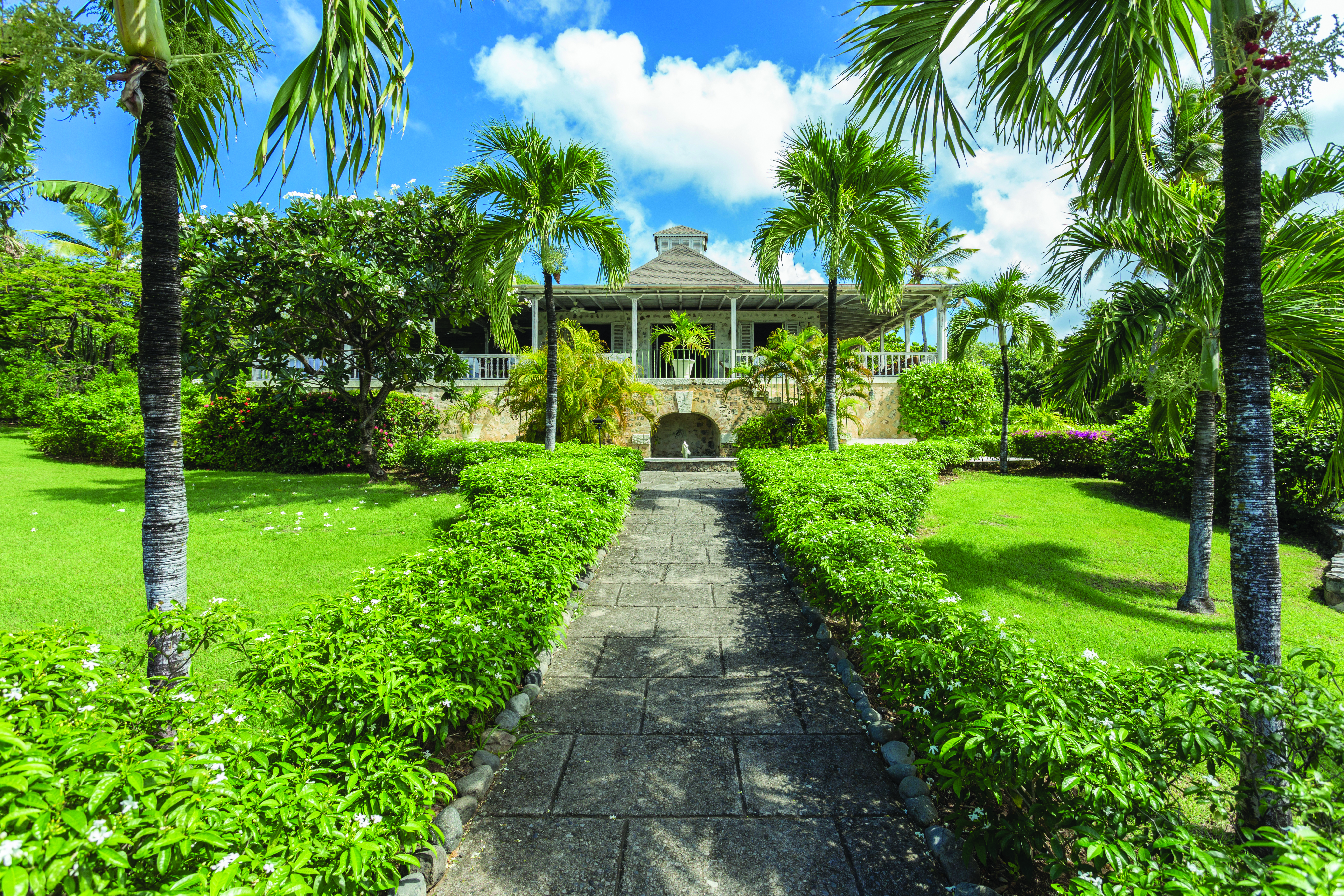 Cotton House St Vincent and the Grenadines path leading up to entrance lawns and palm trees
