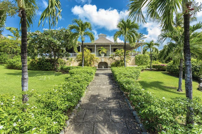 Cotton House St Vincent and the Grenadines path leading up to entrance lawns and palm trees