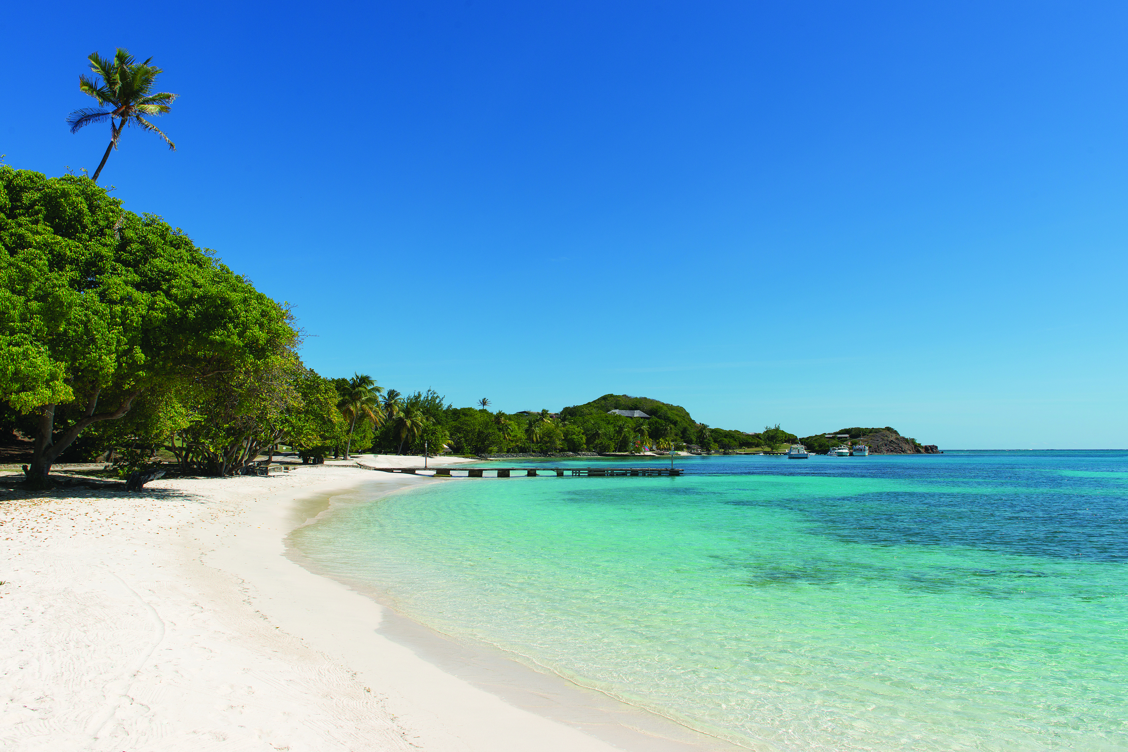 Petit St Vincent beach jetty white sandy beach clear blue ocean