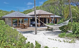 Petit St Vincent beach villa exterior decking out door seating sun loungers hammock