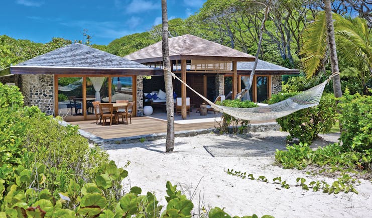 Petit St Vincent beach villa exterior decking out door seating sun loungers hammock